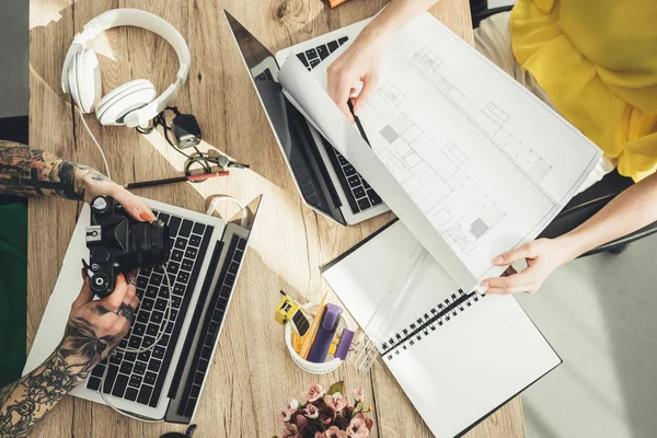 Overhead view of blogger and photographer working at table together in office — Stock Photo