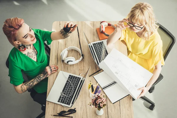 Visão geral do blogueiro e designer trabalhando na mesa juntos no escritório — Fotografia de Stock