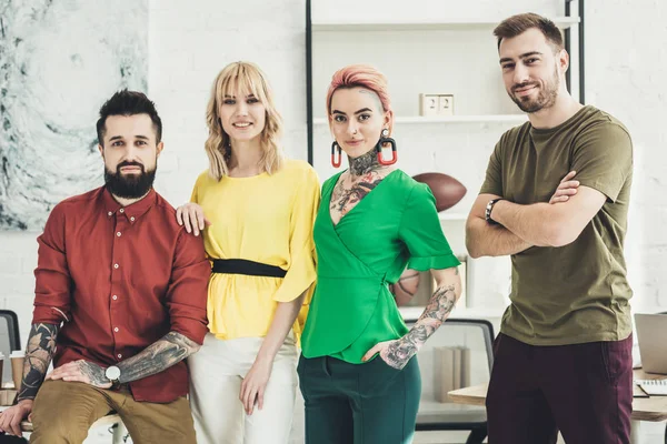 Retrato de grupo de jovens trabalhadores criativos elegantes olhando para a câmera no escritório — Fotografia de Stock