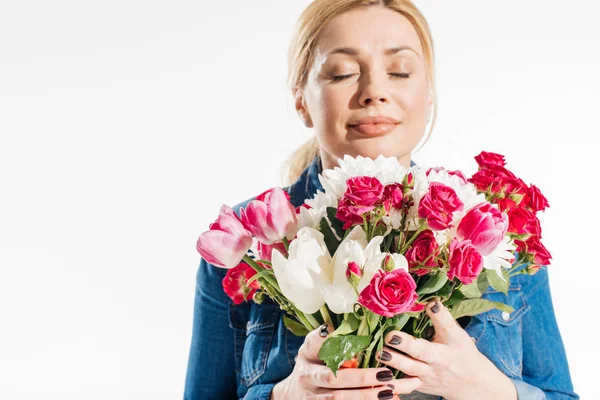 Mujer atractiva oliendo flores de primavera aisladas en blanco - foto de stock