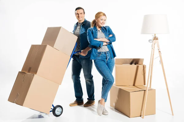 Couple déplacer des boîtes en carton sur le chariot à main isolé sur blanc — Photo de stock