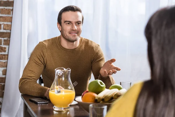 Enfoque selectivo de la pareja hablando durante el desayuno en casa - foto de stock