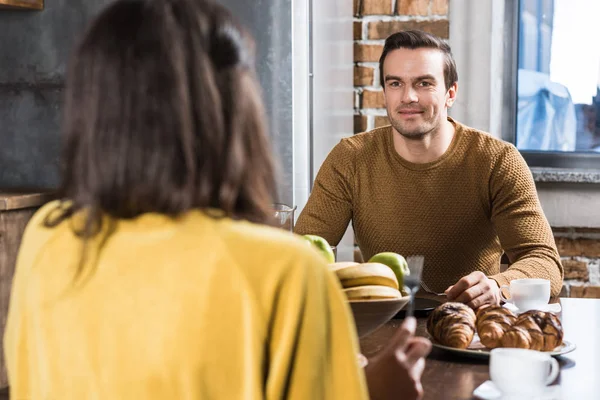 Foyer sélectif de couple se regardant tout en prenant le petit déjeuner ensemble à la maison — Photo de stock