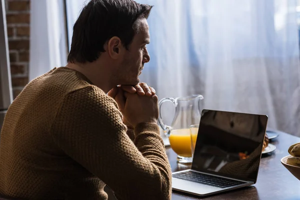 Side view of man using laptop with blank screen at home — Stock Photo