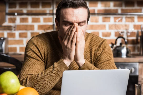 Uomo esausto utilizzando il computer portatile a casa — Foto stock