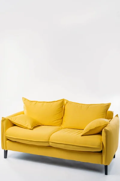 Студийный снимок триумфального желтого дивана на белом — стоковое фото