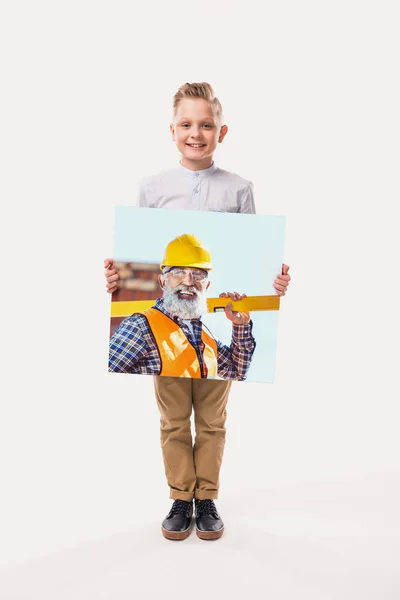 Маленький улыбающийся мальчик, притворяющийся рабочим, изолированный на белом — стоковое фото
