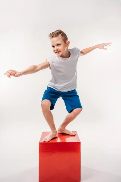 Niño sonriente fingiendo ser un surfista, aislado en blanco - foto de stock