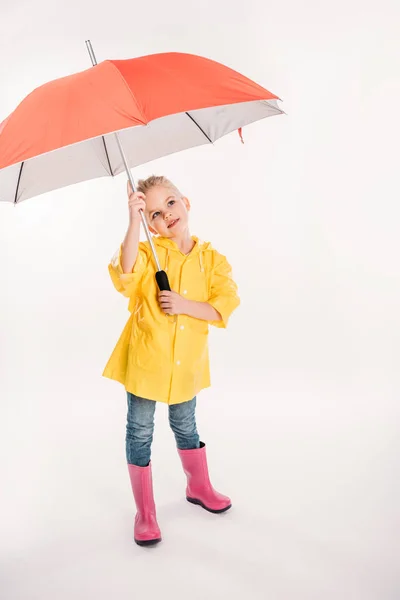 Niño pequeño en impermeable amarillo con paraguas, aislado en blanco - foto de stock