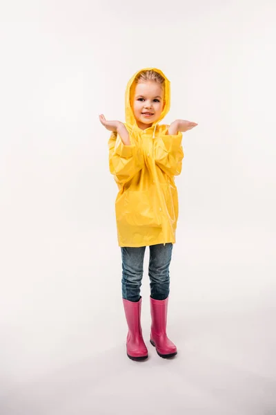 Petit enfant en imperméable jaune et bottes en caoutchouc, isolé sur blanc — Photo de stock