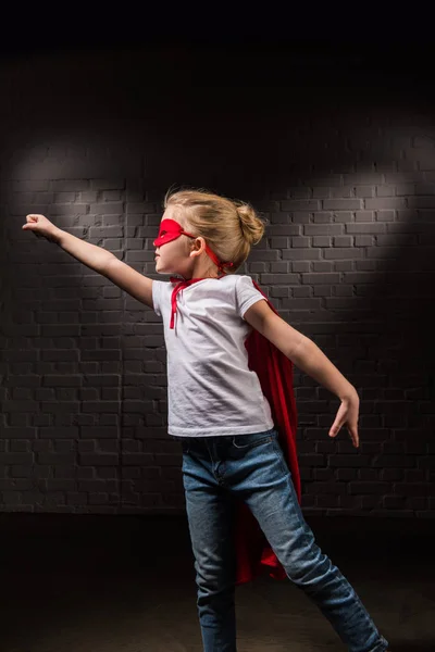 Criança fêmea voando em máscara de super-herói vermelho e voando — Fotografia de Stock