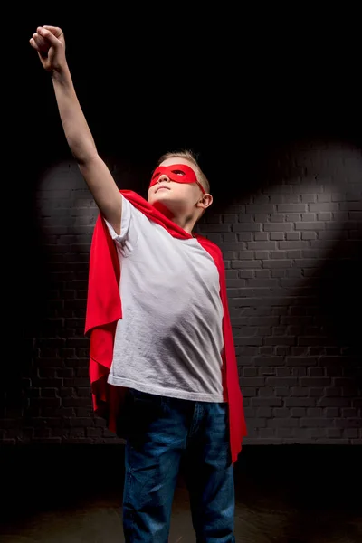 Niño volando en traje de superhéroe y máscara roja - foto de stock