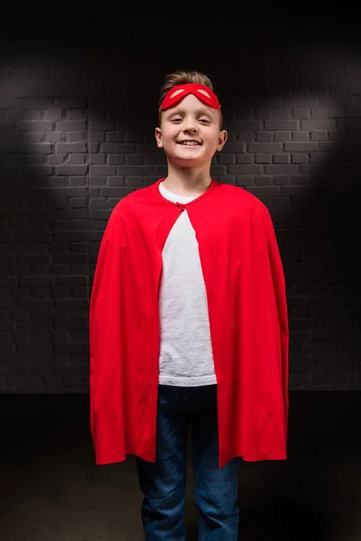 Sonriente niño en traje de superhéroe y máscara - foto de stock