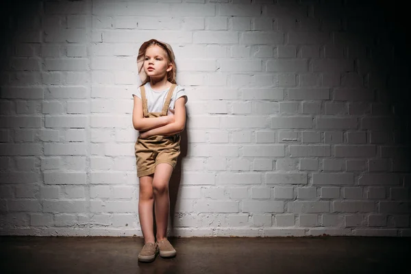 Criança em traje de safári com braços cruzados em pé na parede branca — Fotografia de Stock