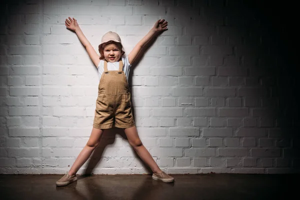 Kleines Kind im Safarikostüm steht an weißer Wand — Stockfoto