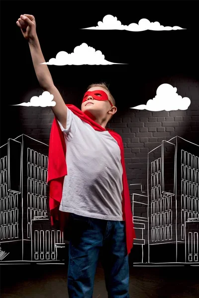 Menino voando em traje de super-herói e máscara vermelha na cidade — Fotografia de Stock