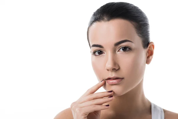 Hermosa chica tocando los labios y mirando a la cámara aislada en blanco - foto de stock