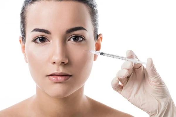 Обрезанный образ косметолога, делающего инъекцию красоты девушке с чистой кожей, изолированной на белом — стоковое фото
