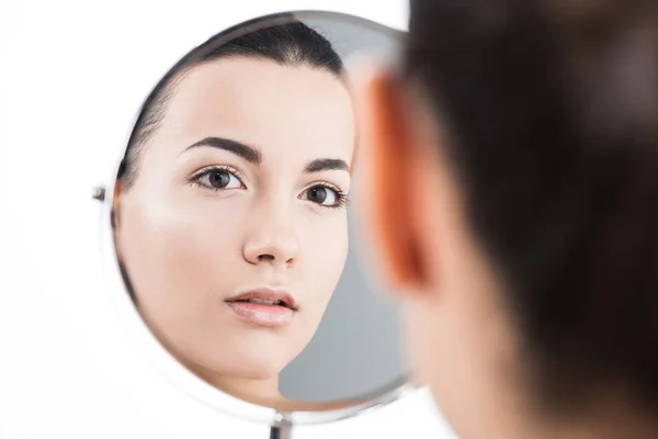 Back view of beautiful girl looking at table mirror isolated on white — Stock Photo