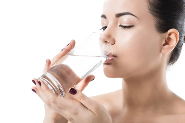 Schönes Mädchen trinkt Wasser aus transparentem Glas isoliert auf weiß — Stockfoto