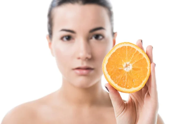 Atractiva chica desnuda con la piel limpia sosteniendo la mitad de naranja aislado en blanco - foto de stock