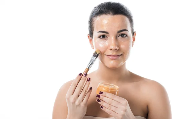 Happy beautiful girl applying honey mask with brush isolated on white — Stock Photo