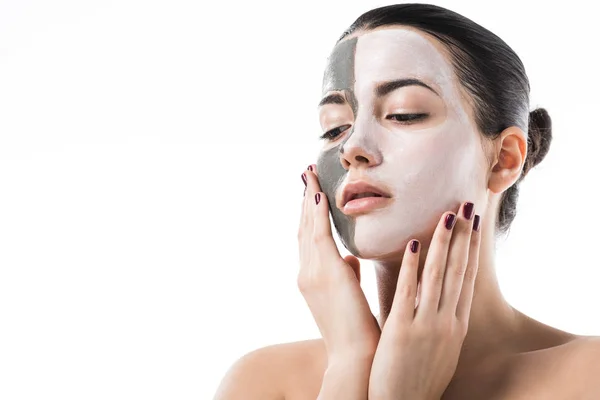 Hermosa chica con diferentes mascarillas faciales cosméticas tocando la cara aislada en blanco - foto de stock