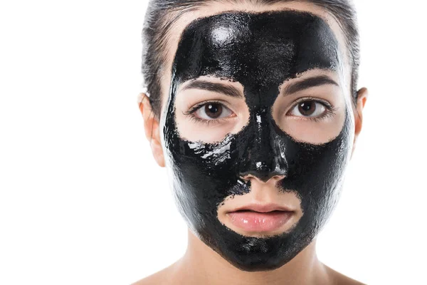 Tiro na cabeça de menina em máscara facial de barro preto cosmético isolado em branco — Fotografia de Stock