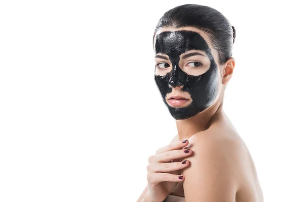 Beautiful girl in cosmetic black clay facial mask with naked shoulder isolated on white — Stock Photo