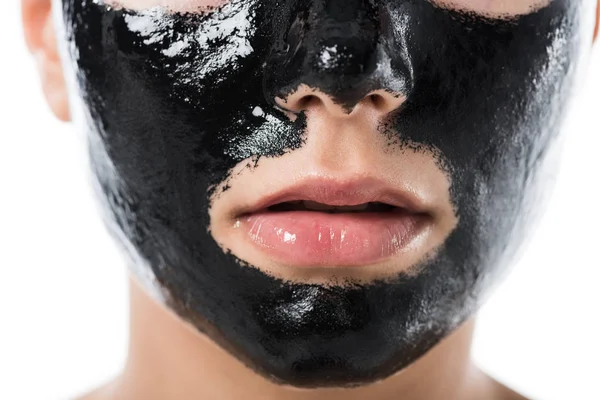 Imagem cortada de menina com máscara cosmética preta facial isolada em branco — Fotografia de Stock