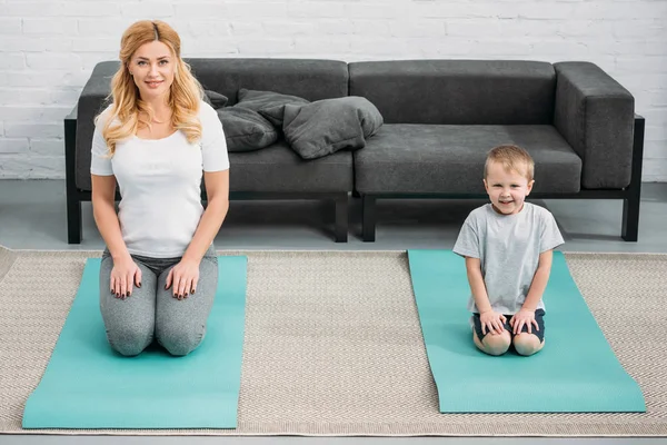 Sohn und Mutter ruhen sich auf Fitnessmatten aus — Stockfoto