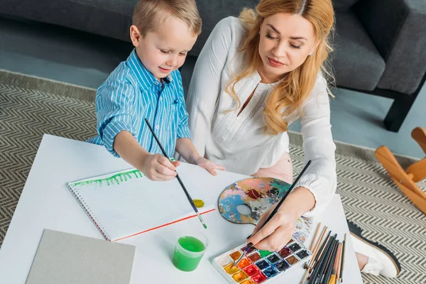 Счастливый маленький мальчик и мама рисуют вместе — стоковое фото
