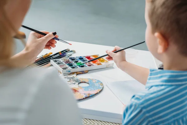 Vista posteriore di madre e figlio pittura insieme — Foto stock