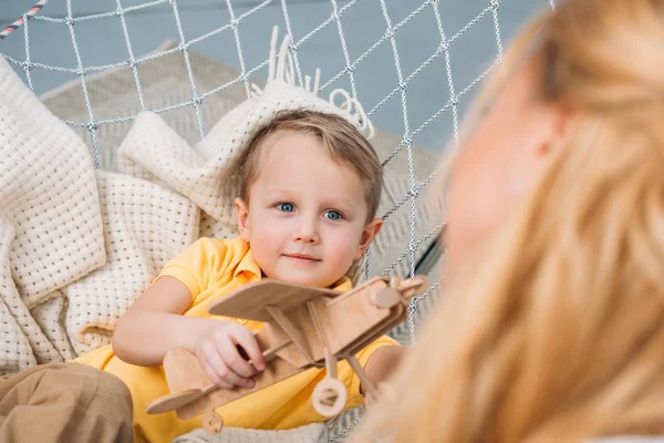 Imagem cortada de mãe e filho brincando com brinquedo de avião de madeira na rede — Fotografia de Stock