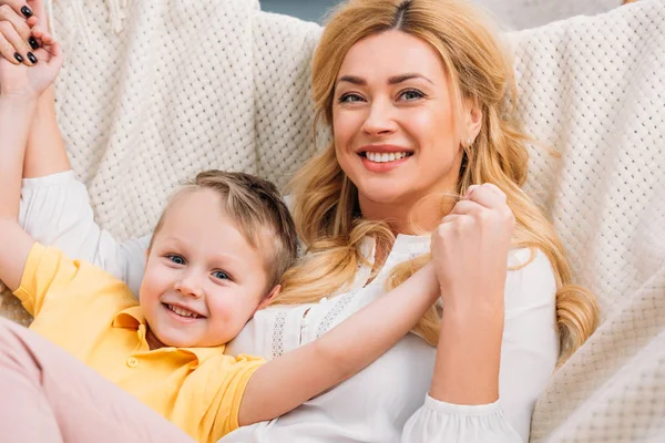 Happy mother holding little son hands in hammock — Stock Photo