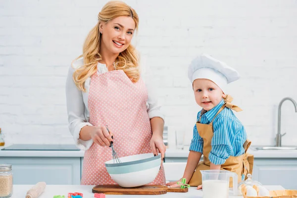 Niño y madre cocinando juntos en la cocina - foto de stock