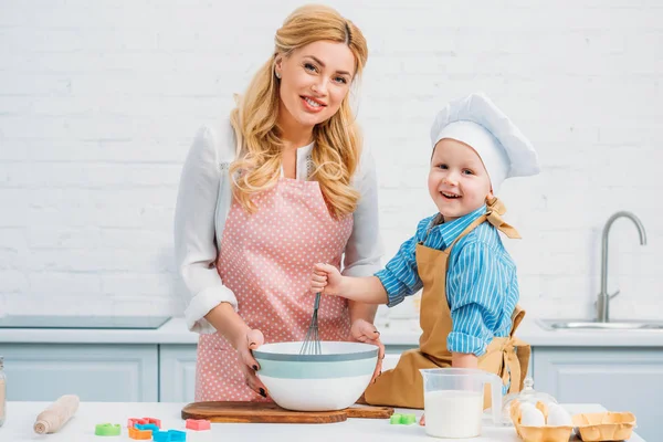 Mother and little son in kitchen cooking together — Stock Photo