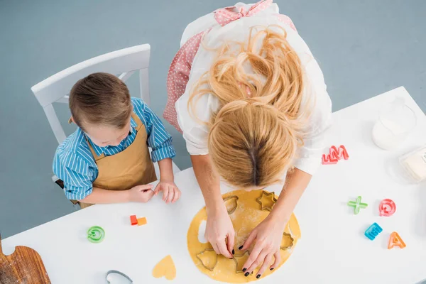 Vista ad alto angolo di figlio e madre utilizzando stampi di cottura — Foto stock