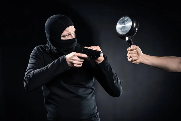 Thief with gun being hit by frying pan — Stock Photo