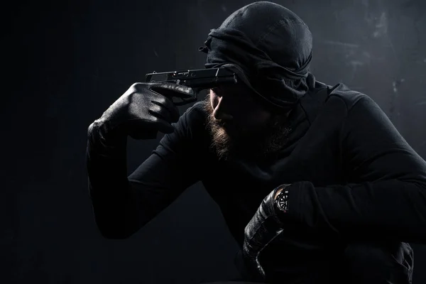 Burglar in balaclava scratching his head with gun — Stock Photo