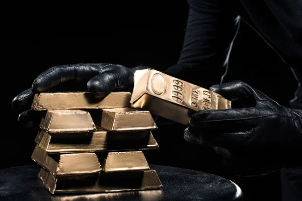 Close-up view of golden bars in hands of thief — Stock Photo
