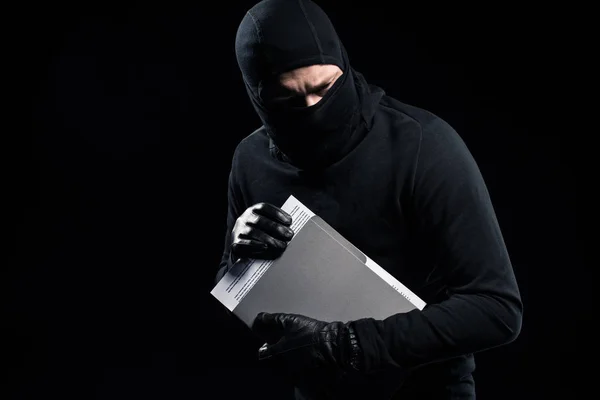 Burglar in balaclava holding top secret documents — Stock Photo