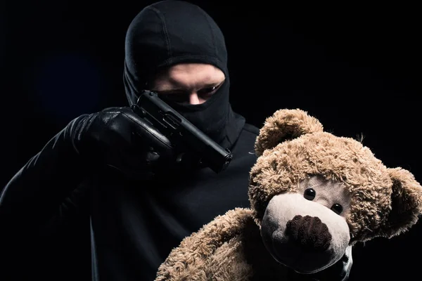 Ladrão em Balaclava apontando para ursinho de pelúcia — Fotografia de Stock