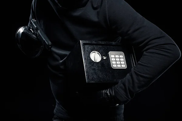 Close-up view of gun and locked safe in hands of thief — Stock Photo