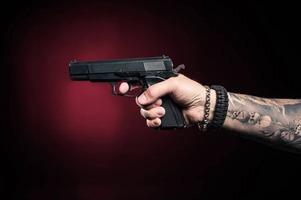 Close-up view of male hand aiming with gun — Stock Photo