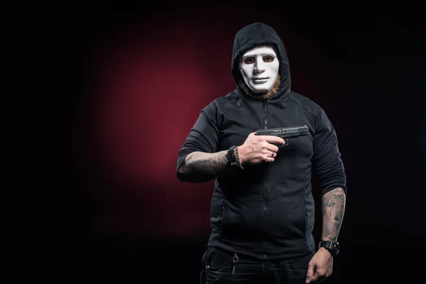 Грабитель в маске и балаклаве с пистолетом — стоковое фото