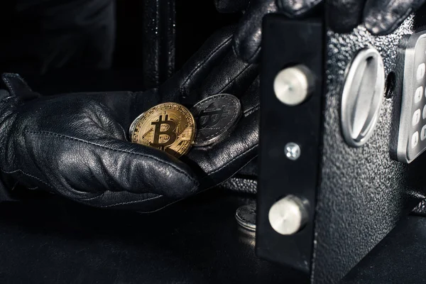 Thief hand stealing golden bitcoin from safe — Stock Photo