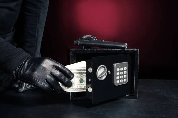 Close-up view of criminal opening safe with dollars — Stock Photo