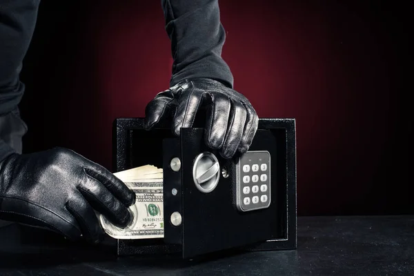 Close-up view of robber with stealing dollar banknotes from safe — Stock Photo