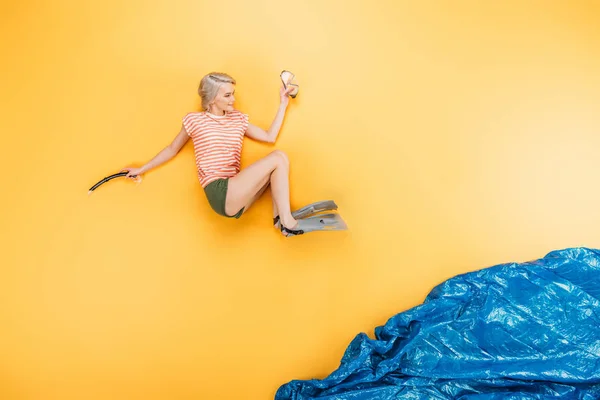 Hermosa mujer joven en aletas saltando en imaginar mar en amarillo, concepto de vacaciones de verano - foto de stock